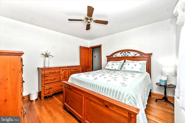 bedroom featuring a ceiling fan, light wood-type flooring, and baseboards