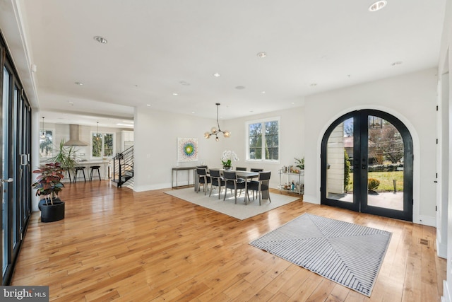 entrance foyer featuring arched walkways, recessed lighting, french doors, and light wood-style floors