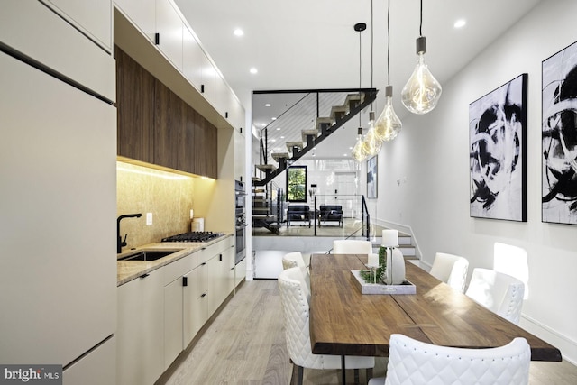 dining area featuring recessed lighting, stairway, and light wood finished floors