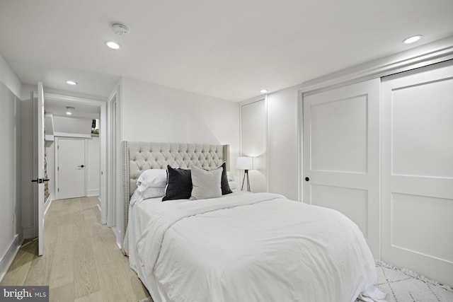 bedroom featuring recessed lighting, light wood-type flooring, and a closet