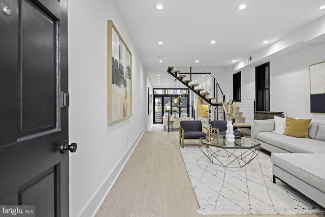 living area with visible vents, light wood-style flooring, recessed lighting, baseboards, and stairs