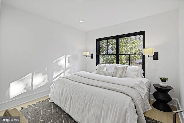 bedroom with recessed lighting, wood finished floors, and baseboards