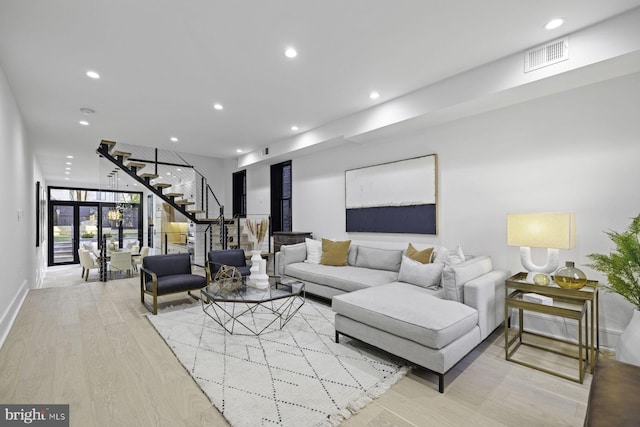 living room featuring stairway, recessed lighting, visible vents, and light wood finished floors