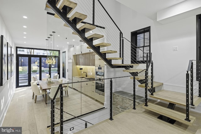 staircase with recessed lighting, baseboards, and wood finished floors