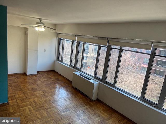 empty room featuring radiator and ceiling fan