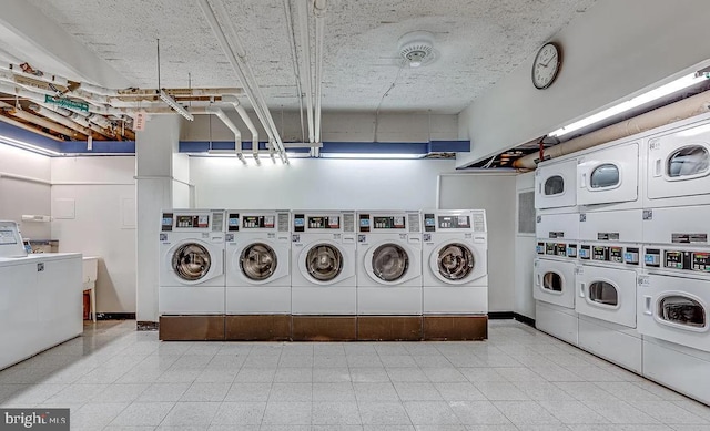 common laundry area featuring stacked washing maching and dryer, baseboards, and washing machine and clothes dryer