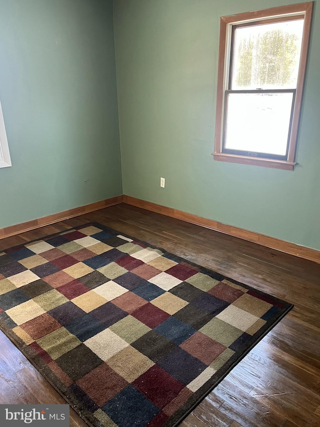 empty room featuring baseboards and wood finished floors