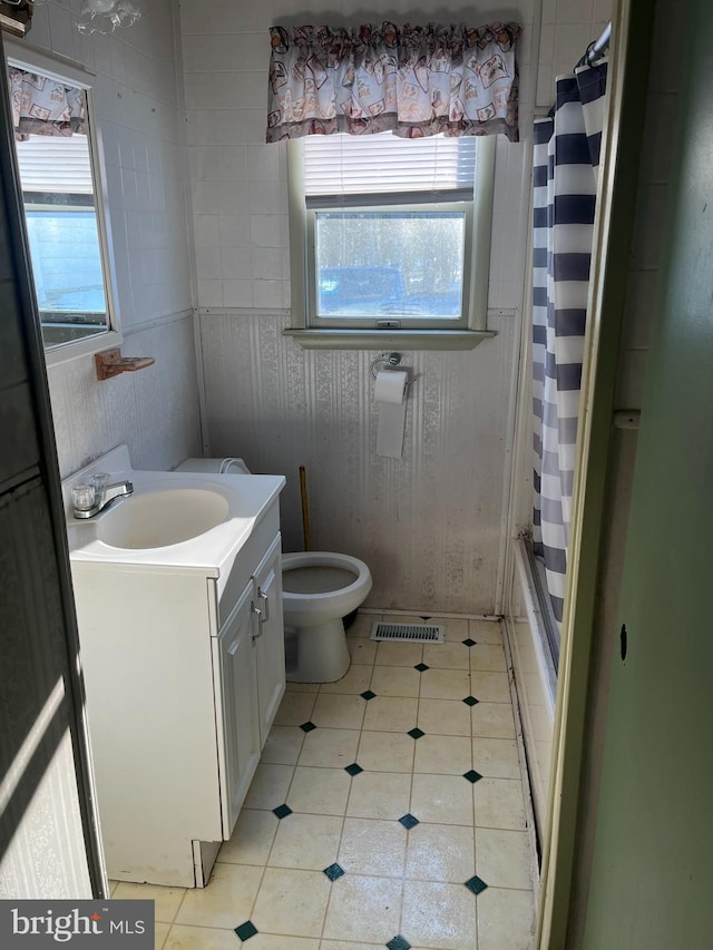 bathroom featuring visible vents, toilet, shower / tub combo, tile patterned floors, and vanity