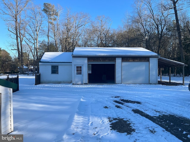 snow covered garage featuring a detached garage