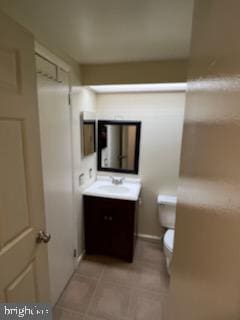 bathroom featuring vanity, tile patterned floors, and toilet