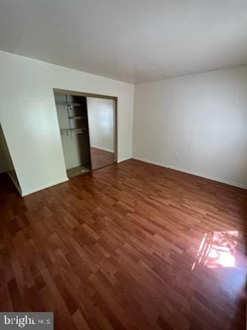 unfurnished bedroom with wood finished floors and a closet