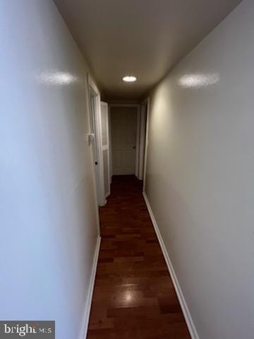 hall featuring recessed lighting, baseboards, and dark wood-style flooring