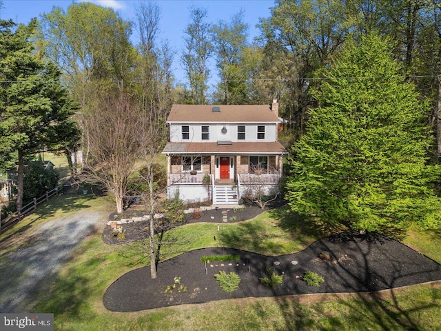 view of front of property featuring a front yard, a porch, and a chimney