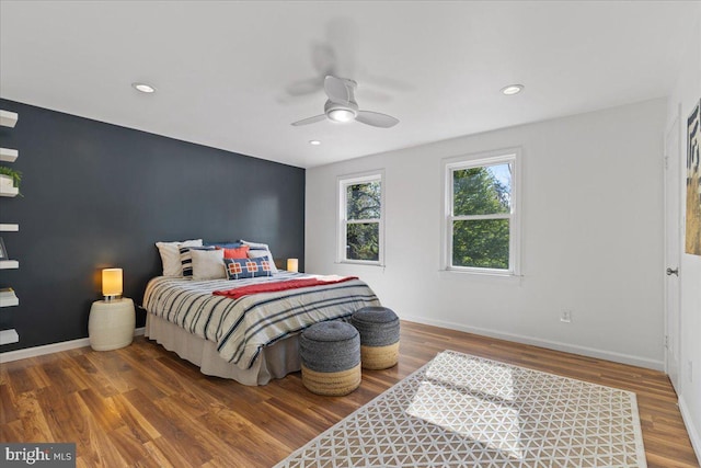 bedroom featuring baseboards, wood finished floors, and recessed lighting