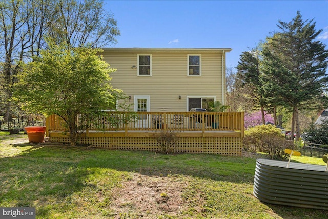 rear view of house featuring a lawn and a deck