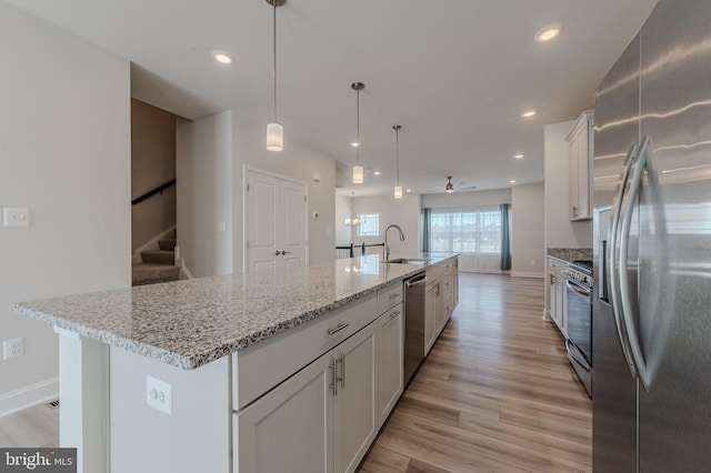 35416 Wright Way, Millsboro, DE 19966 - kitchen featuring a sink, light wood-style floors, a kitchen island with sink, white cabinetry, and appliances with stainless steel finishes