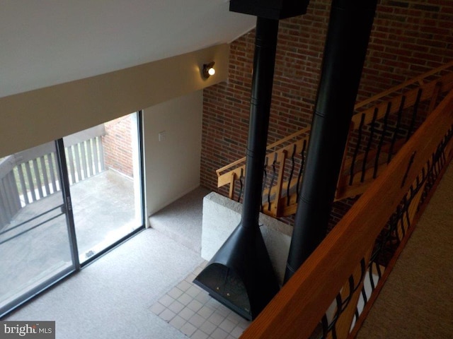 stairway with carpet, a healthy amount of sunlight, and a wood stove