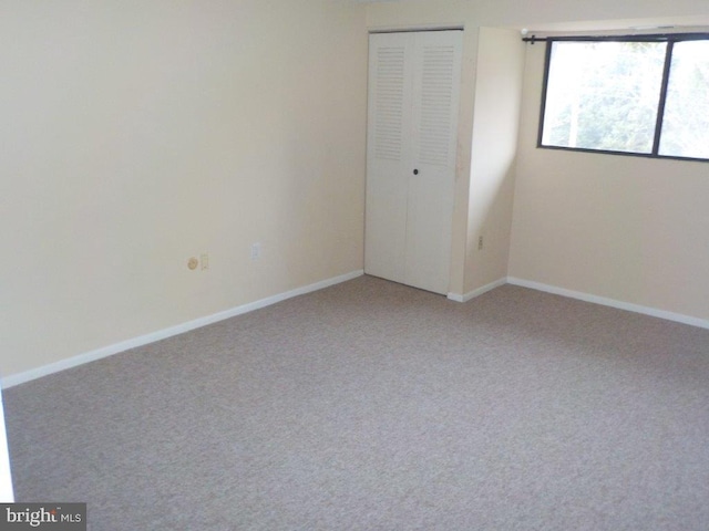 empty room with baseboards and light carpet