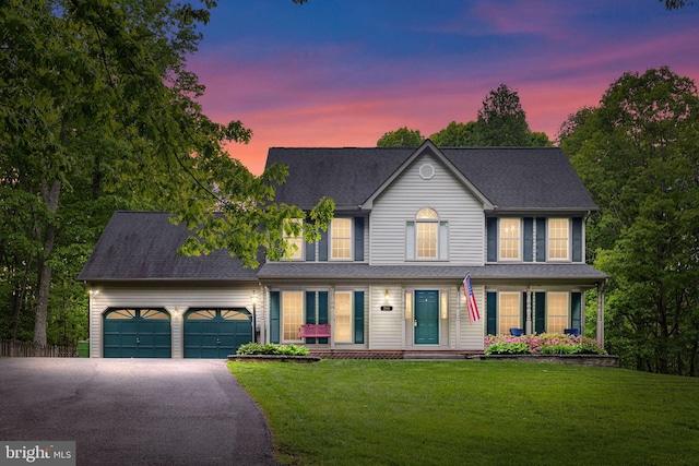 view of front of property with a garage, a front lawn, and driveway