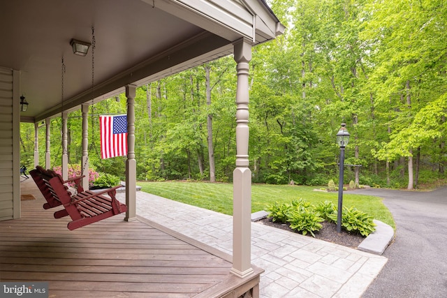 deck featuring a patio area and a lawn