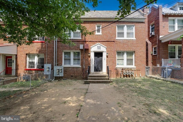 view of property featuring fence and brick siding