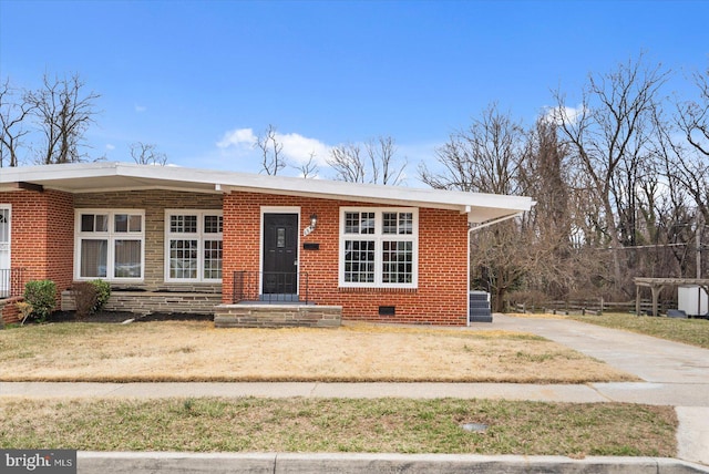 view of front of property with cooling unit, a front yard, brick siding, and driveway