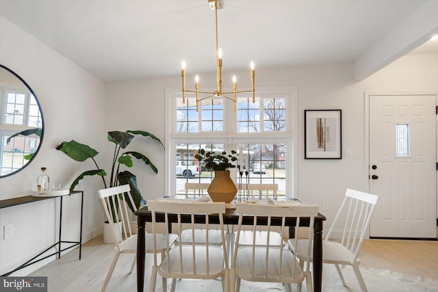 dining space featuring a notable chandelier, baseboards, and wood finished floors