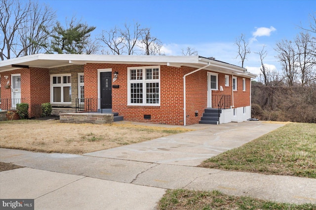 view of front facade featuring crawl space, brick siding, and driveway