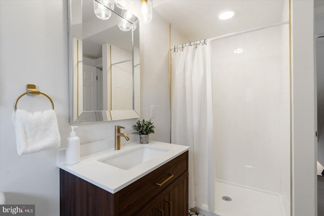 full bath with tiled shower and vanity