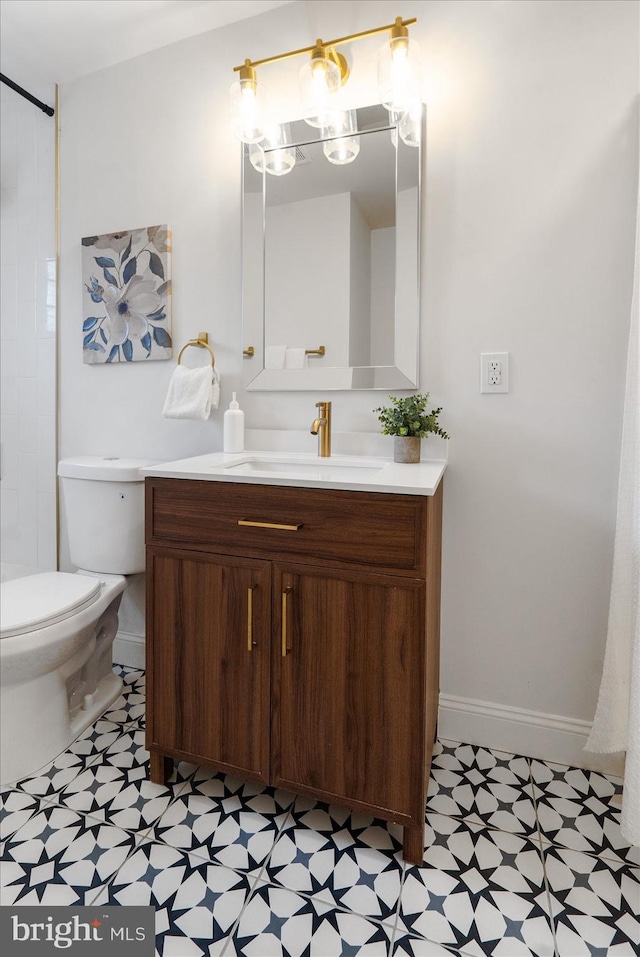 bathroom with vanity, tile patterned floors, toilet, and baseboards