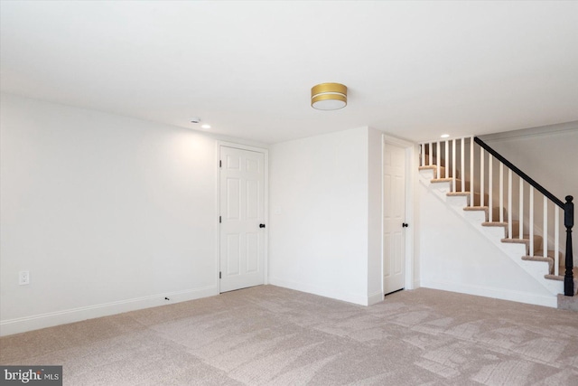 finished below grade area with carpet flooring, recessed lighting, stairway, and baseboards