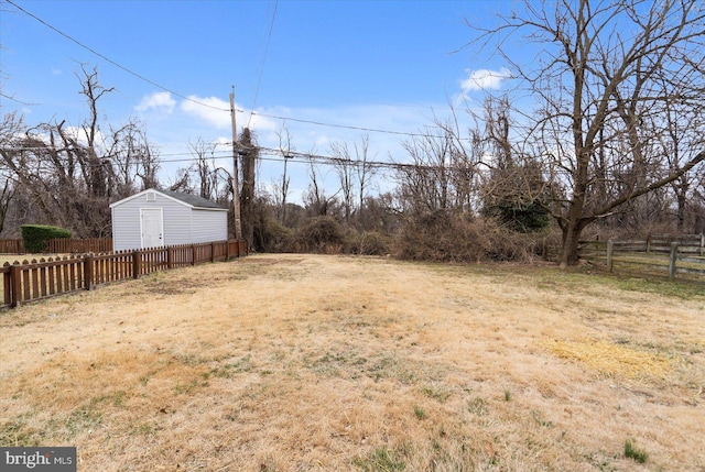 view of yard with an outbuilding, a shed, and fence