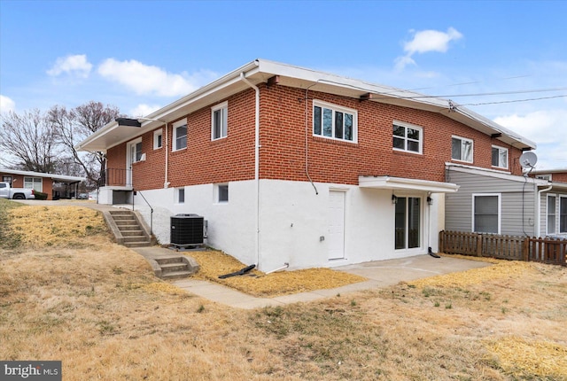 back of property with stairs, cooling unit, stucco siding, and fence