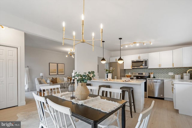 dining room with light wood finished floors and a chandelier