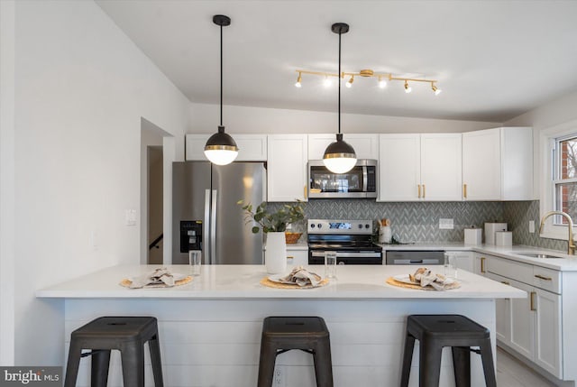 kitchen featuring decorative backsplash, a kitchen breakfast bar, stainless steel appliances, and a sink