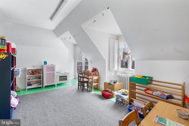 rec room featuring carpet flooring, vaulted ceiling, and radiator