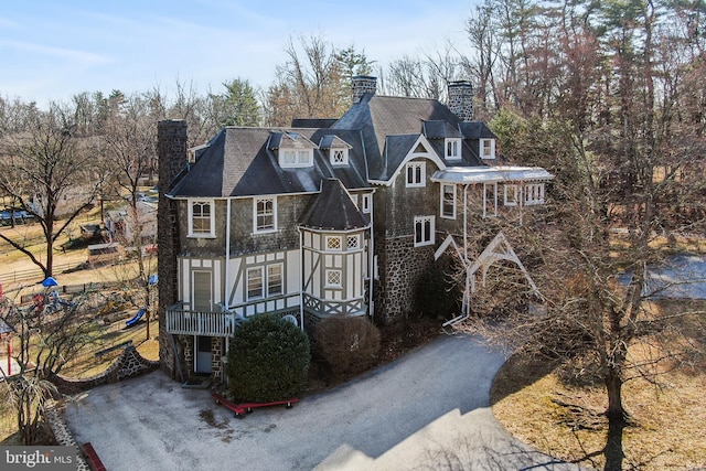 view of front facade featuring driveway and a chimney