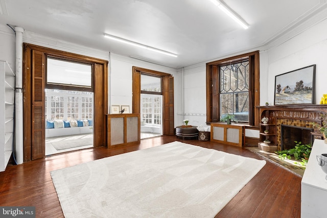 sitting room featuring dark wood finished floors, a fireplace, and crown molding