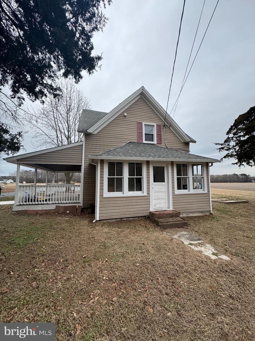 view of front of home featuring an attached carport, a front lawn, and roof with shingles