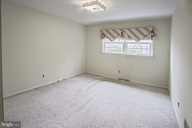 spare room featuring visible vents, baseboards, and carpet flooring