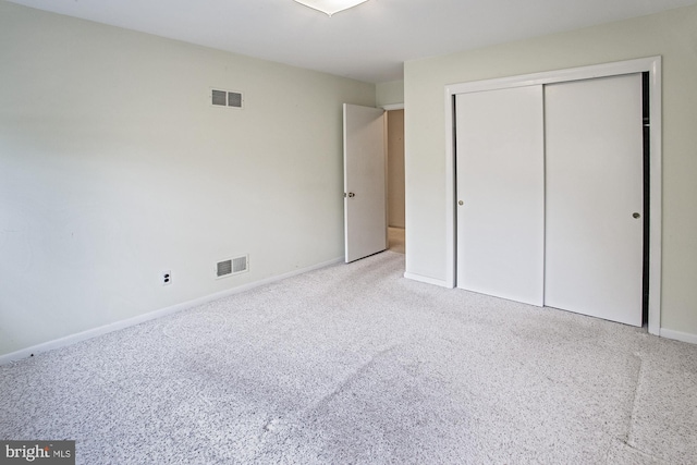 unfurnished bedroom featuring visible vents, baseboards, carpet floors, and a closet