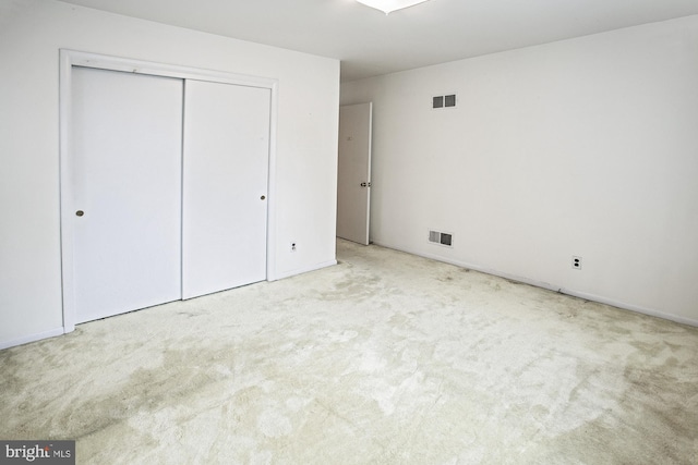 unfurnished bedroom with a closet, visible vents, and carpet floors