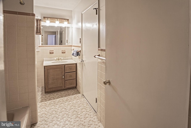 full bath with tile walls and vanity