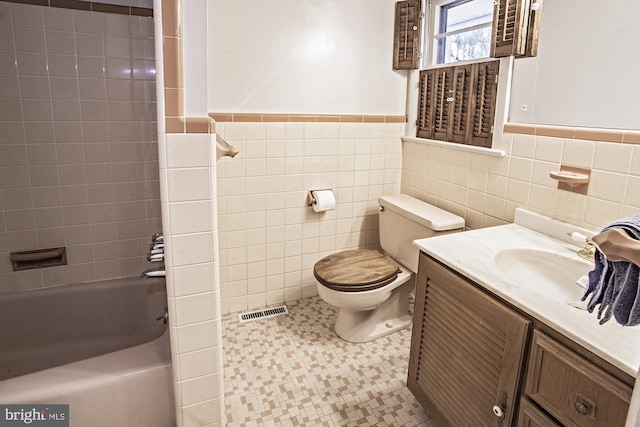 full bathroom featuring visible vents, toilet, tile walls, and vanity