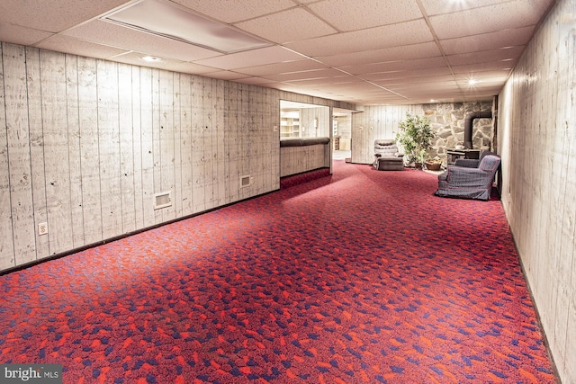 finished basement featuring a paneled ceiling and carpet