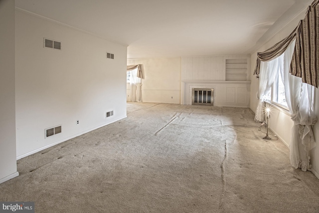 unfurnished living room with visible vents and a glass covered fireplace