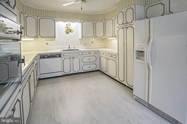 kitchen featuring white appliances, a ceiling fan, light wood-style flooring, a sink, and light countertops