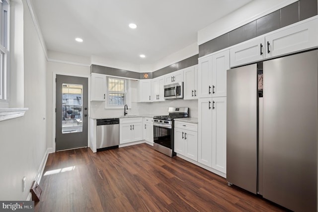 kitchen with dark wood-type flooring, recessed lighting, appliances with stainless steel finishes, white cabinetry, and a sink