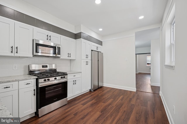 kitchen featuring baseboards, appliances with stainless steel finishes, dark wood-style floors, and white cabinetry