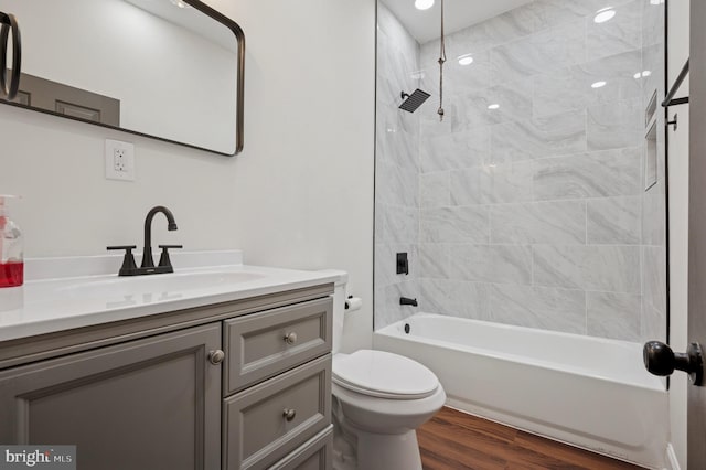 bathroom featuring toilet, vanity, shower / bathtub combination, and wood finished floors